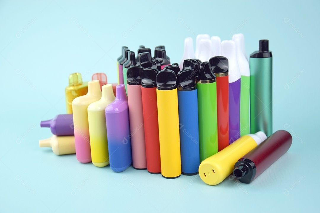 Muitos cigarros eletrônicos descartáveis ​​multicoloridos em um fundo azul