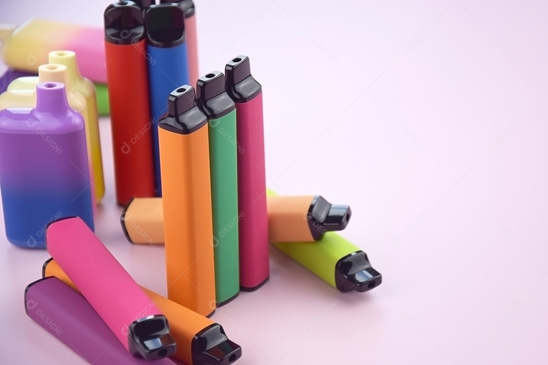 Vários cigarros eletrônicos descartáveis ​​multicoloridos em um fundo rosa