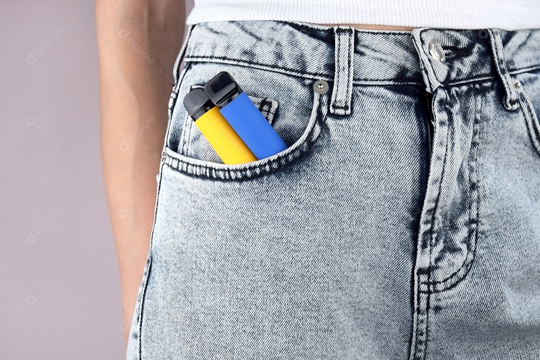 Bolso de jeans com cigarro eletrônico sobre fundo claro