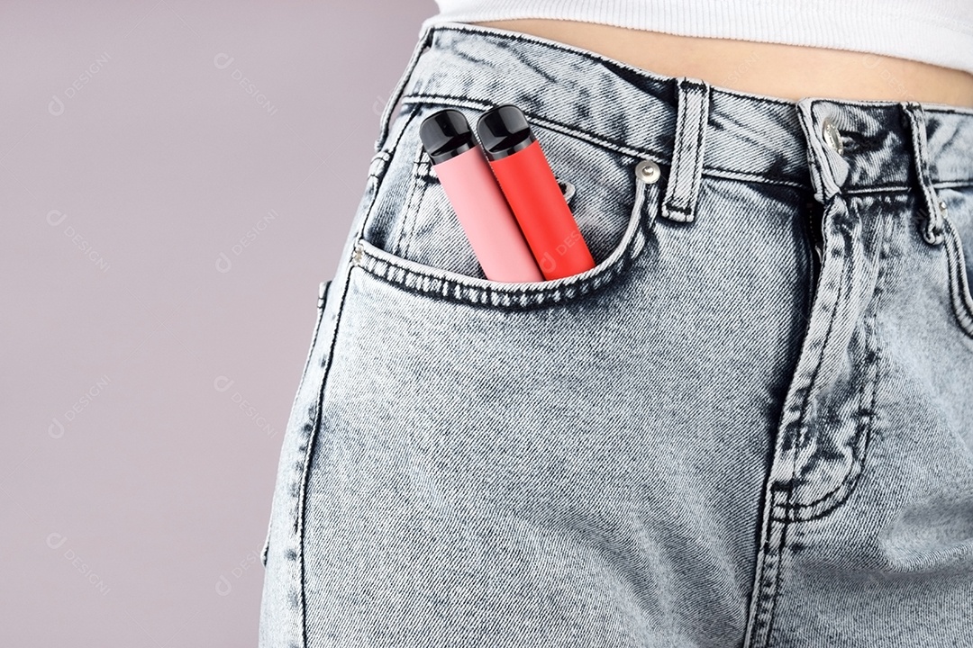 Calça jeans e cigarro eletrônico em bolso sobre fundo claro