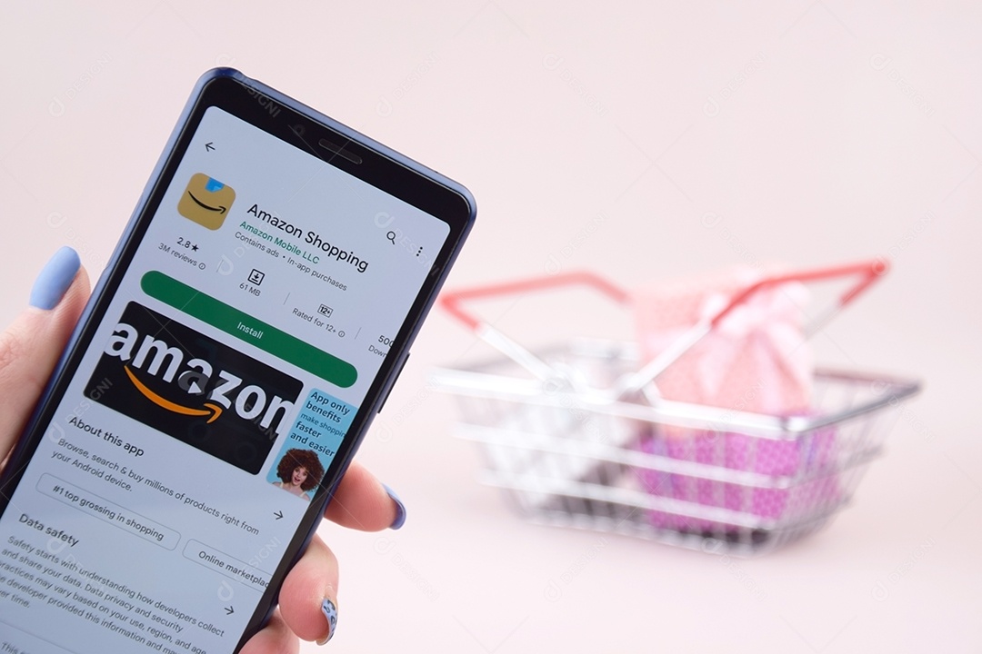 Cesta de compras com celular abriu o logotipo Amazon na tela em um fundo rosa