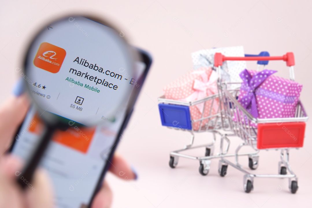 Carro de compras com um smartphone abriu o logotipo do Alibaba na tela em um fundo rosa