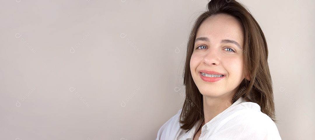 Jovem sorrindo usando aparelho ortodôntico