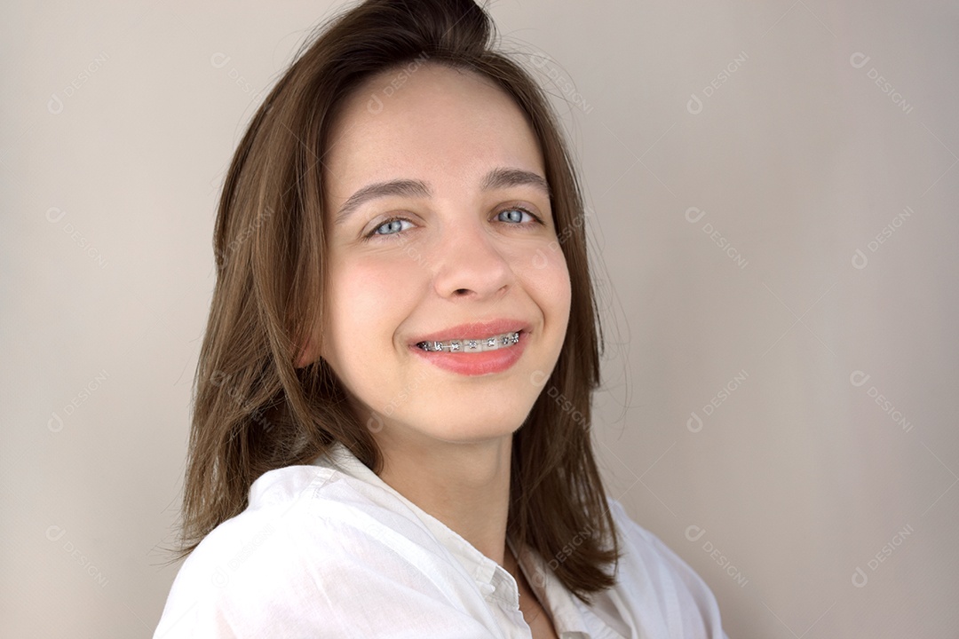 Jovem sorrindo usando aparelho ortodôntico