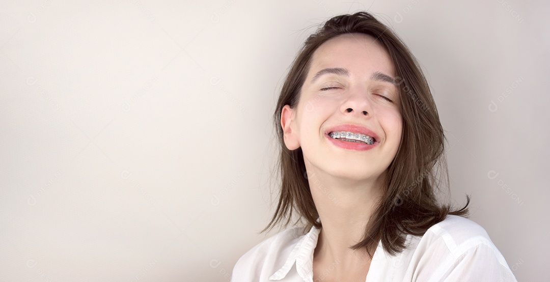 Uma jovem sorrindo com aparelho odontológico