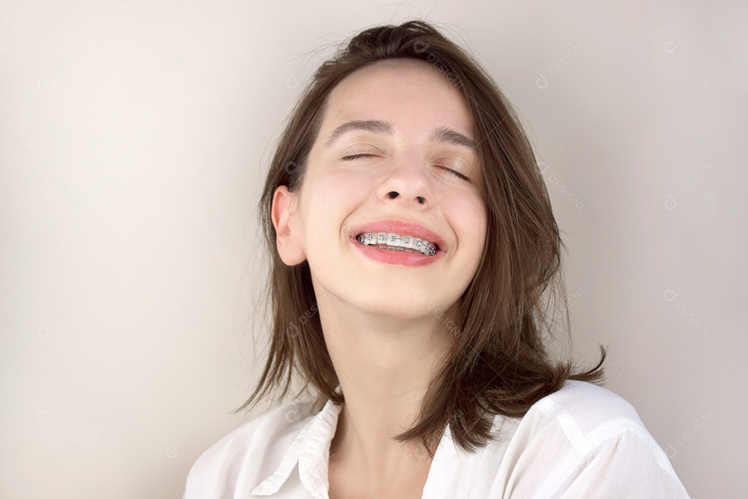 Uma jovem sorrindo com aparelho odontológico