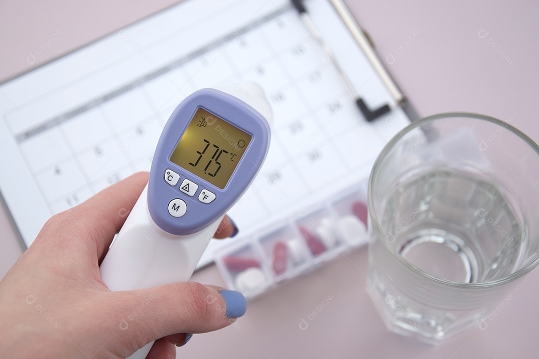 Mão feminina com termômetro copo remédios sobre fundo claro