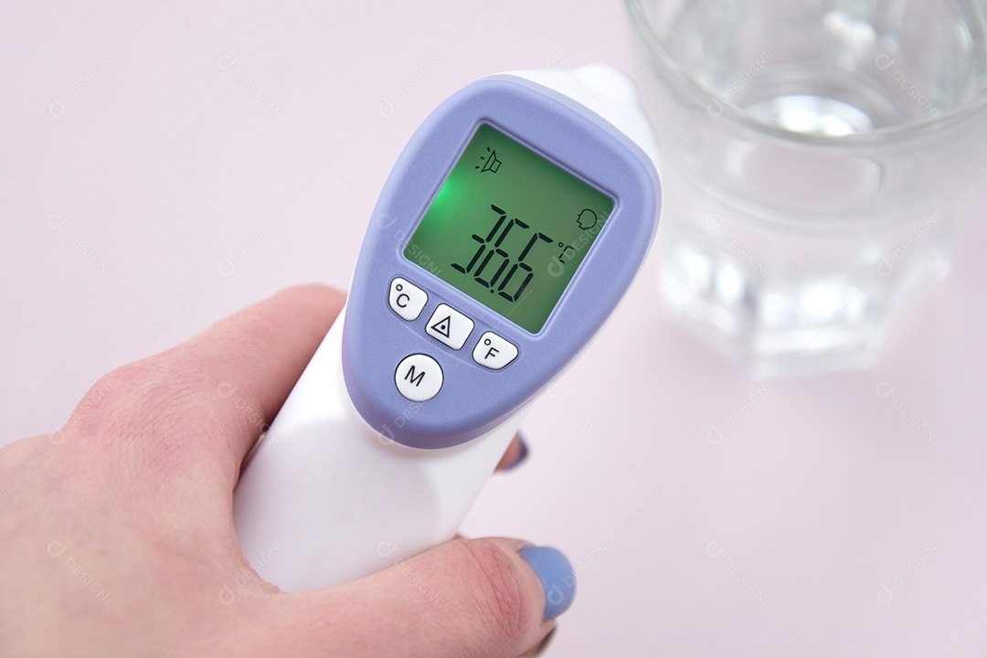 Termômetro digital em mão feminina sobre fundo claro