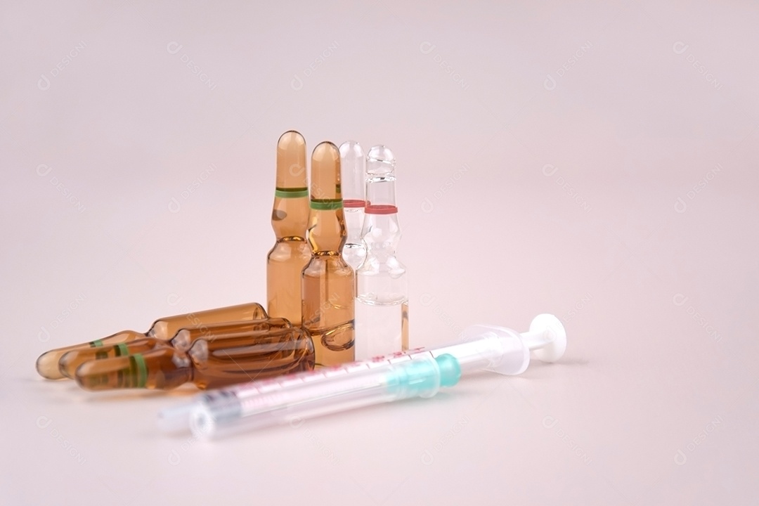 Ampolas de medicamentos e seringa sobre fundo claro