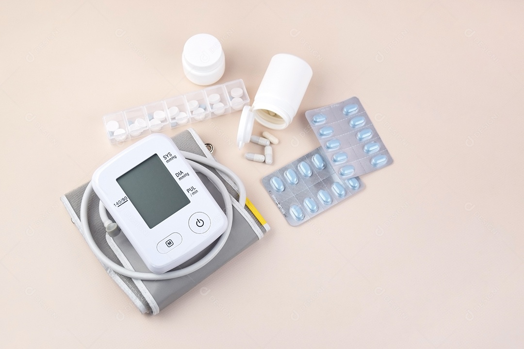 Aparelho digital de pressão arterial e pote de comprimidos em um fundo claro
