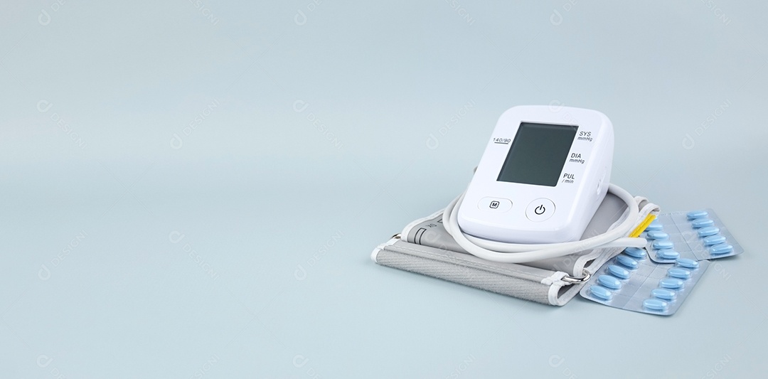 Aparelho digital de pressão arterial e pacote de comprimidos em um fundo claro
