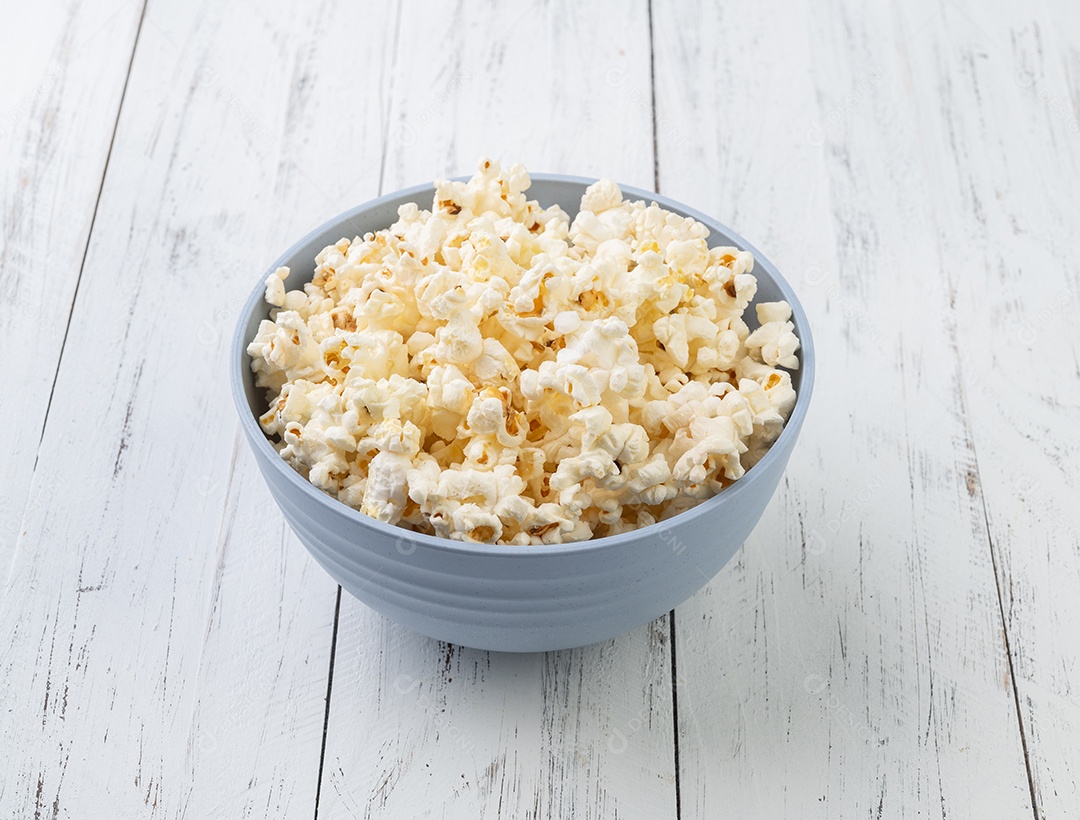 Pipocas em uma tigela sobre a mesa de madeira