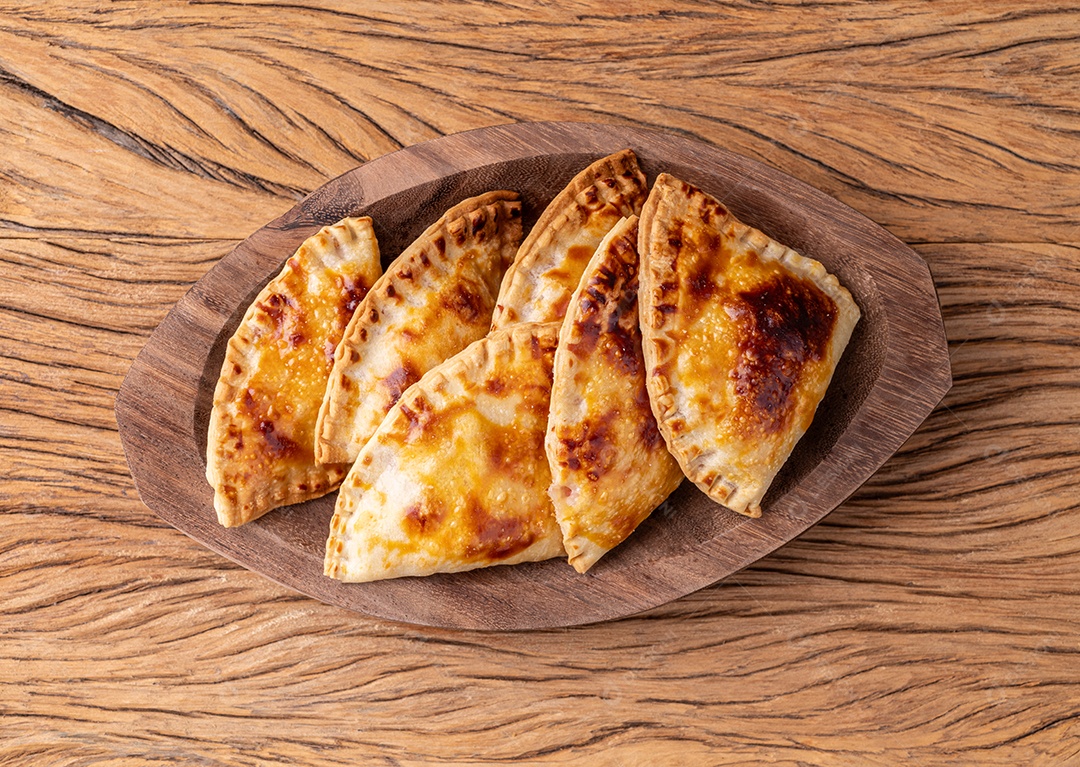 Lanche passtel assado em um prato sobre a mesa de madeira