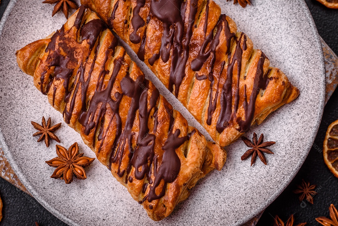 Deliciosa massa folhada crocante com chocolate e caramelo salgado sobre um fundo escuro de concreto