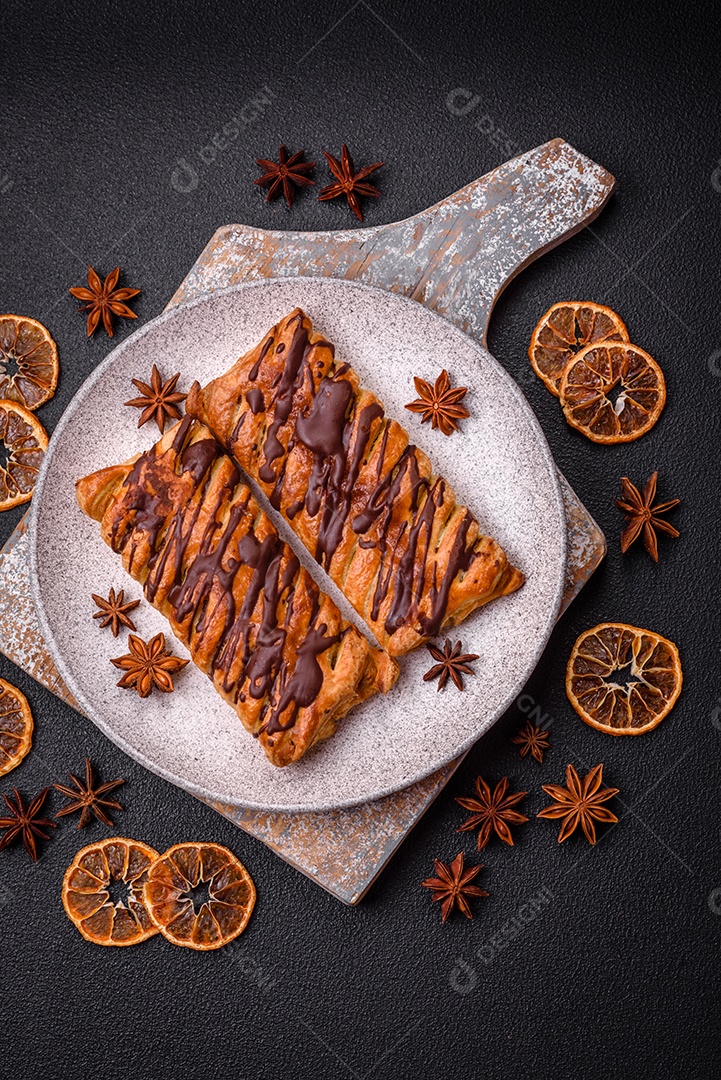 Deliciosa massa folhada crocante com chocolate e caramelo salgado sobre um fundo escuro de concreto