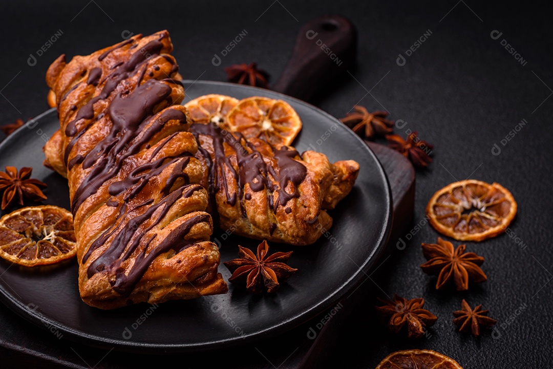 Deliciosa massa folhada crocante com chocolate e caramelo salgado sobre um fundo escuro de concreto