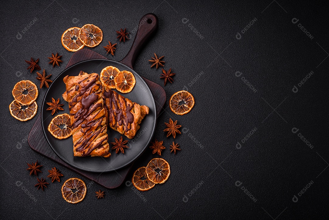 Deliciosa massa folhada crocante com chocolate e caramelo salgado sobre um fundo escuro de concreto