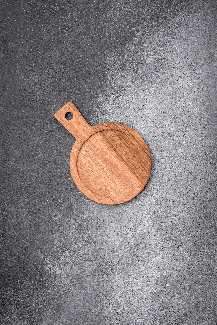 Tábua de corte de madeira vazia sobre um fundo de textura leve. Utensílios de cozinha