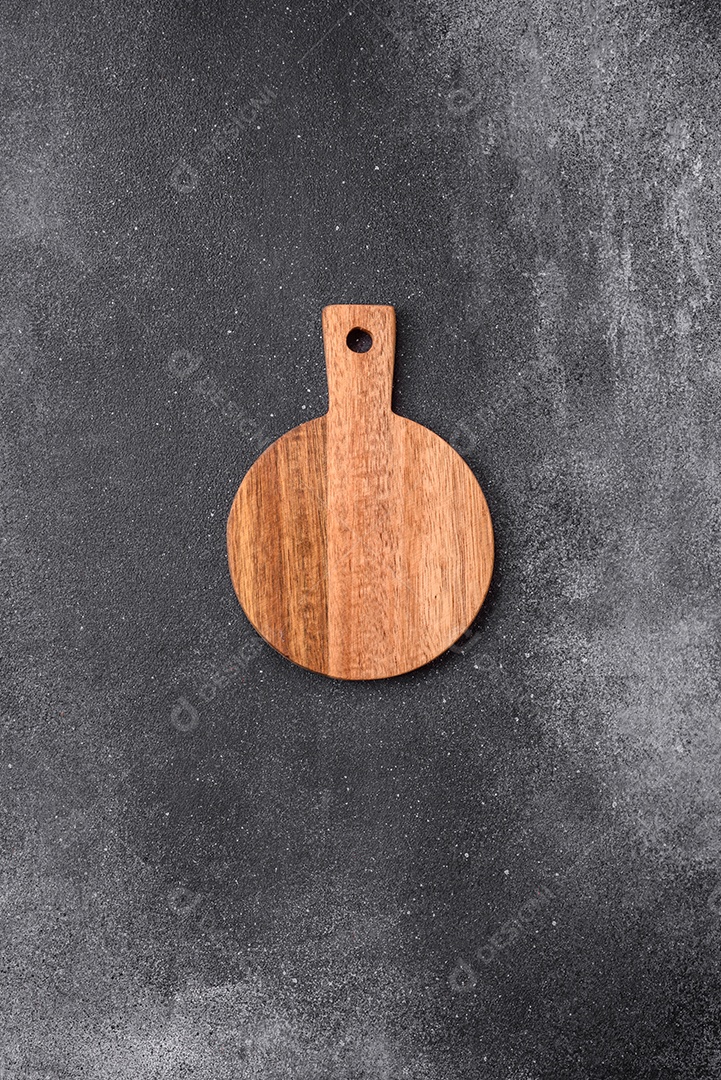 Tábua de corte de madeira vazia sobre um fundo de textura leve. Utensílios de cozinha