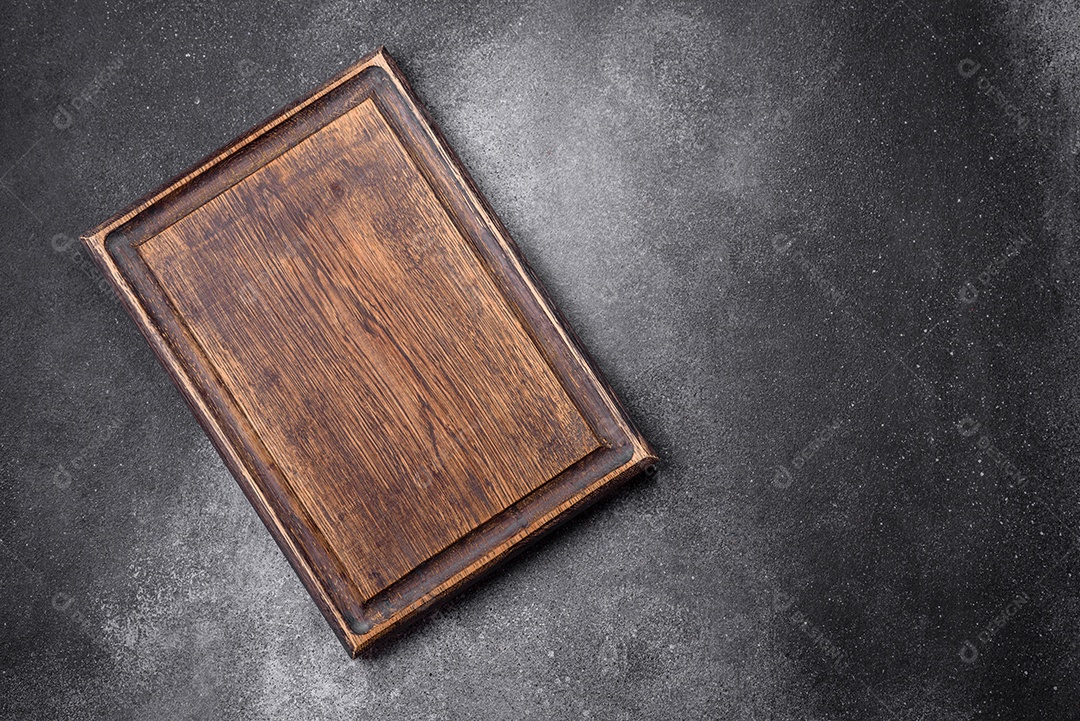 Tábua de corte de madeira vazia sobre um fundo de textura leve. Utensílios de cozinha