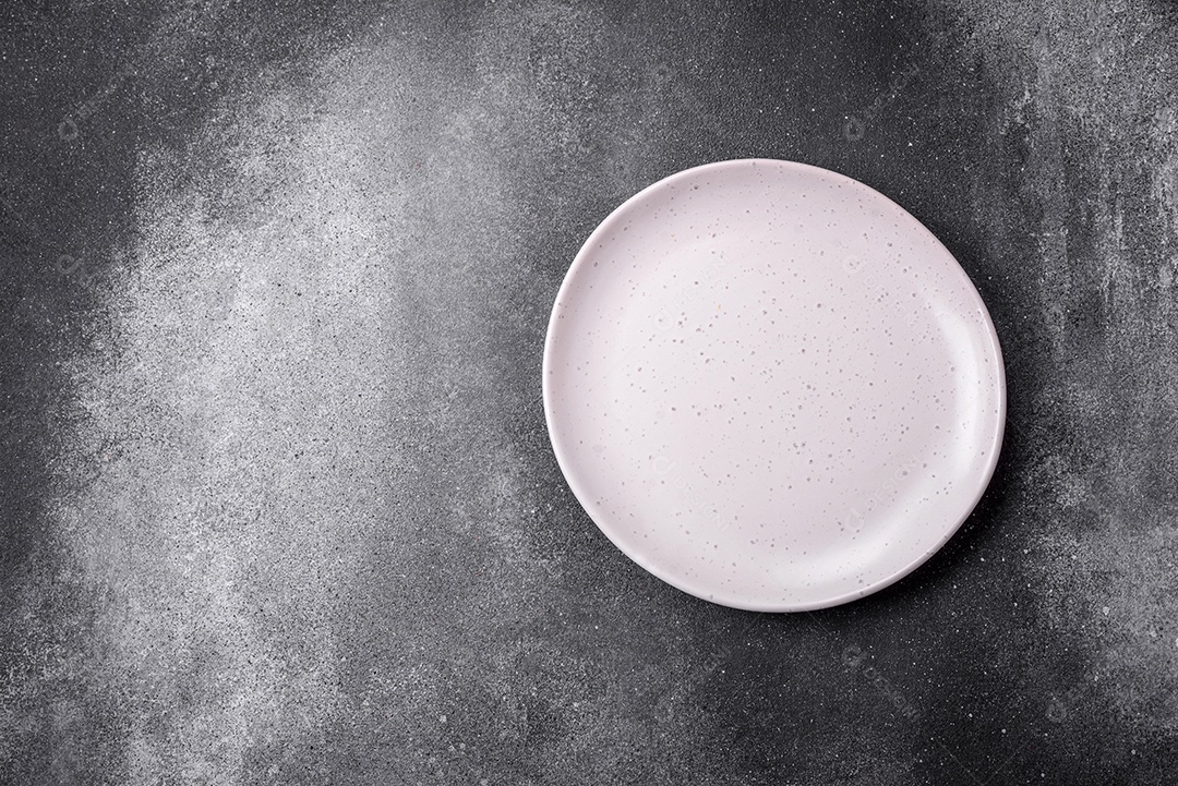 Placa cerâmica redonda vazia sobre um fundo de textura leve. Utensílios de cozinha