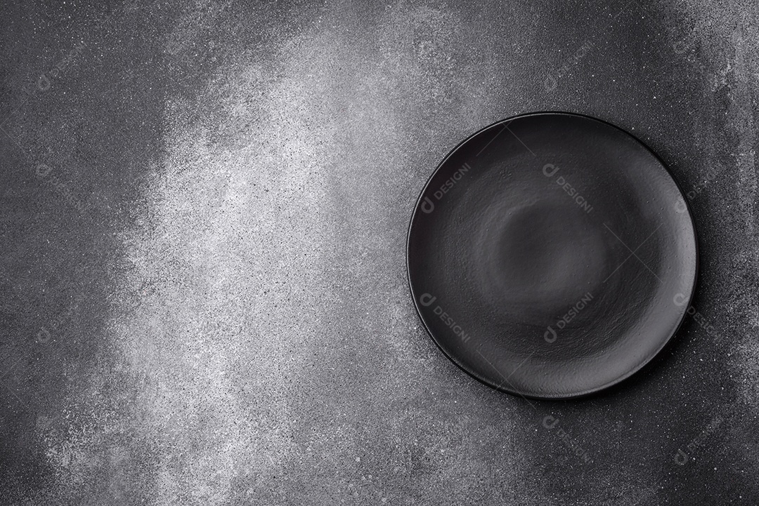 Placa cerâmica redonda vazia sobre um fundo de textura leve. Utensílios de cozinha