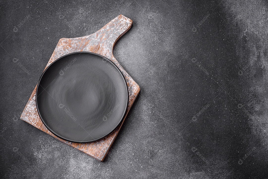 Placa cerâmica redonda vazia sobre um fundo de textura leve. Utensílios de cozinha