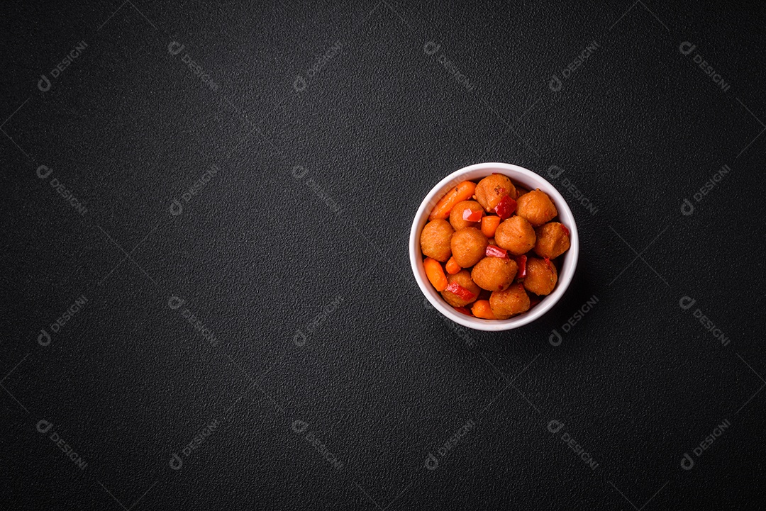 Deliciosas bolas de batata frita com legumes, sal, especiarias e ervas sobre um fundo escuro de concreto