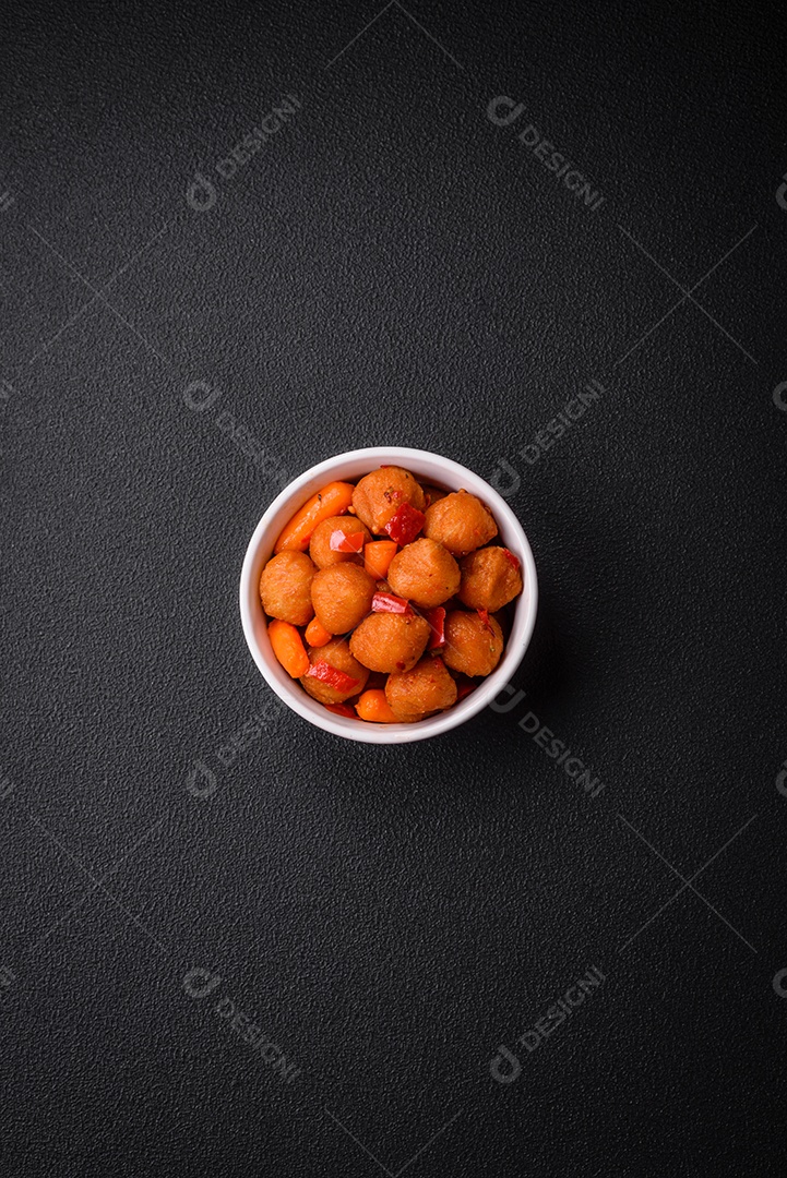 Deliciosas bolas de batata frita com legumes, sal, especiarias e ervas sobre um fundo escuro de concreto