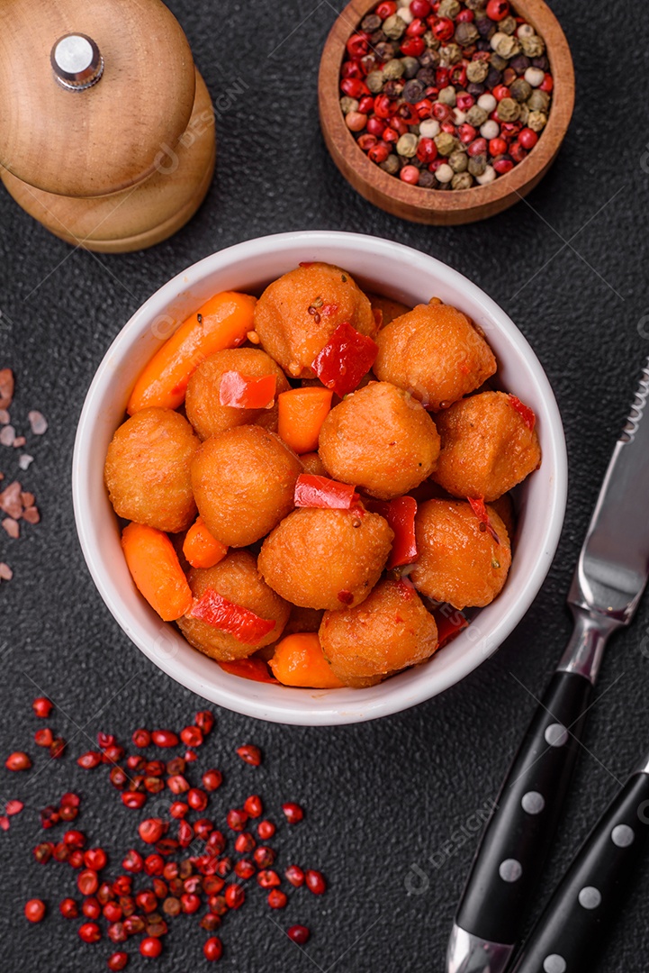 Deliciosas bolas de batata frita com legumes, sal, especiarias e ervas sobre um fundo escuro de concreto