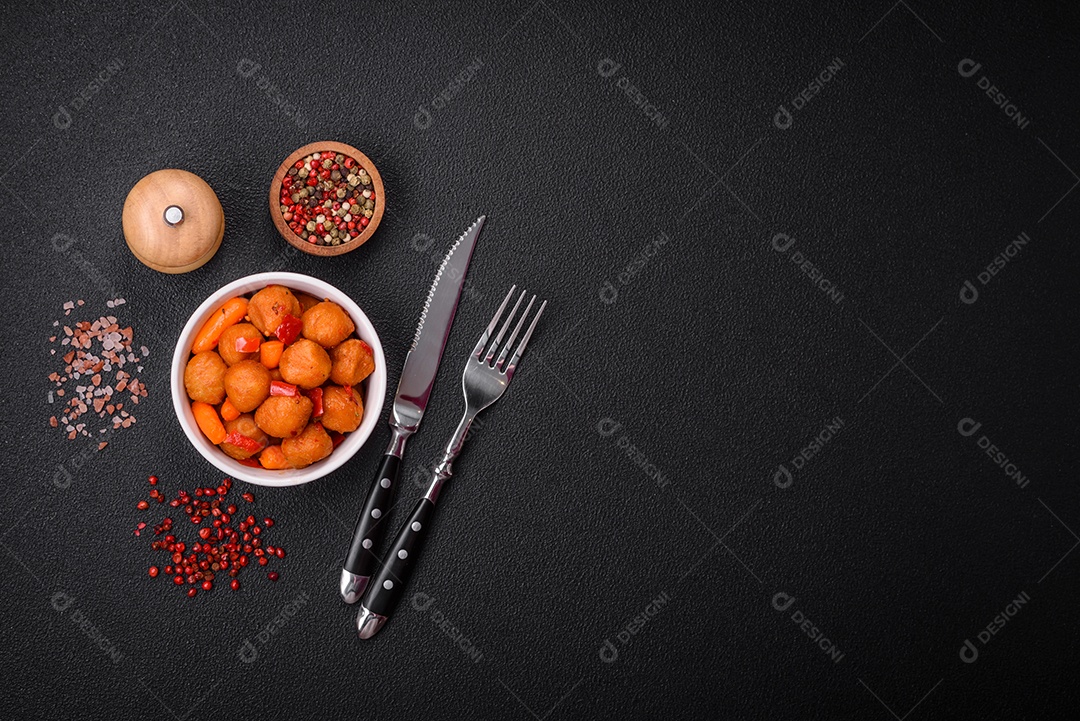 Deliciosas bolas de batata frita com legumes, sal, especiarias e ervas sobre um fundo escuro de concreto