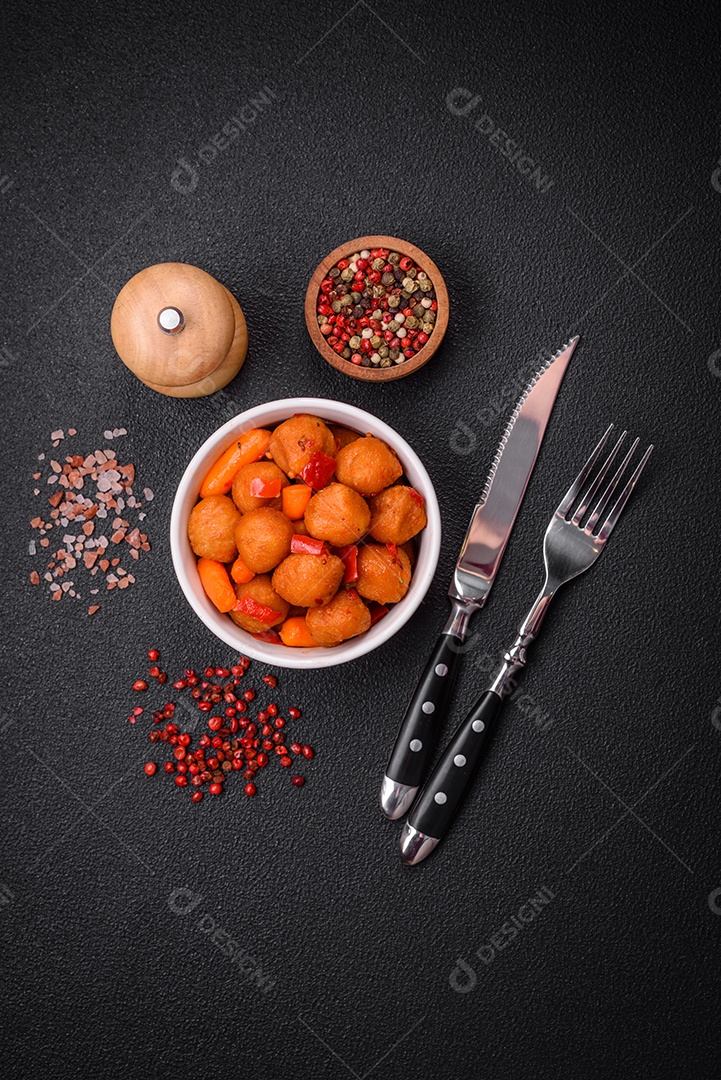 Deliciosas bolas de batata frita com legumes, sal, especiarias e ervas sobre um fundo escuro de concreto