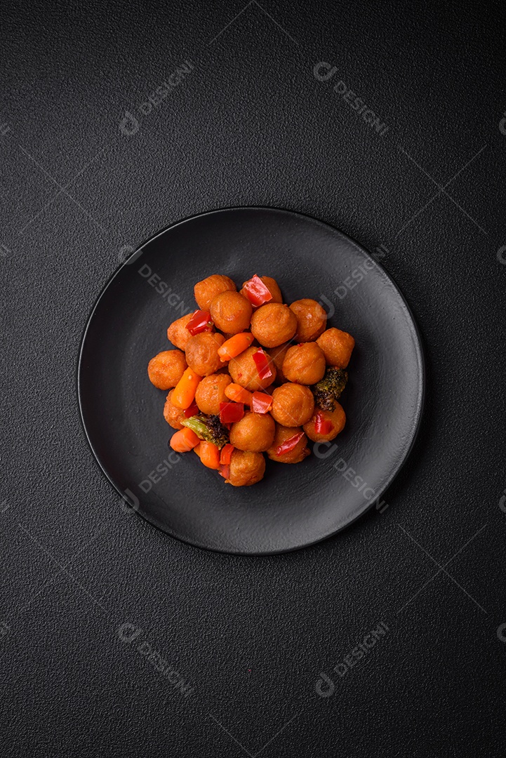 Deliciosas bolas de batata frita com legumes, sal, especiarias e ervas sobre um fundo escuro de concreto