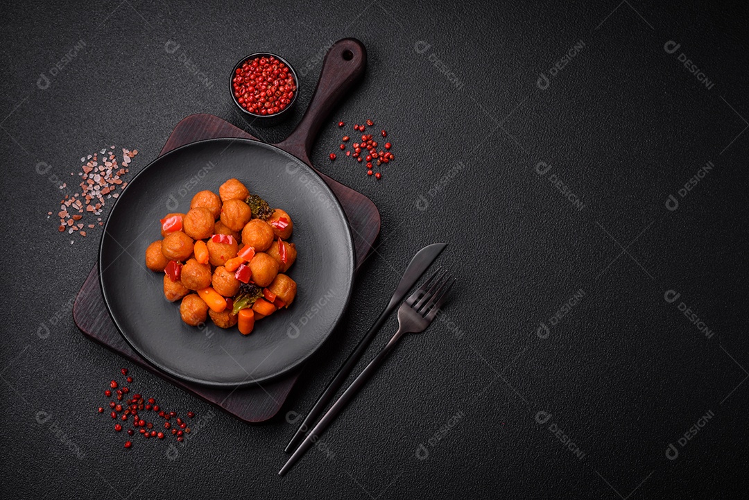 Deliciosas bolas de batata frita com legumes, sal, especiarias e ervas sobre um fundo escuro de concreto