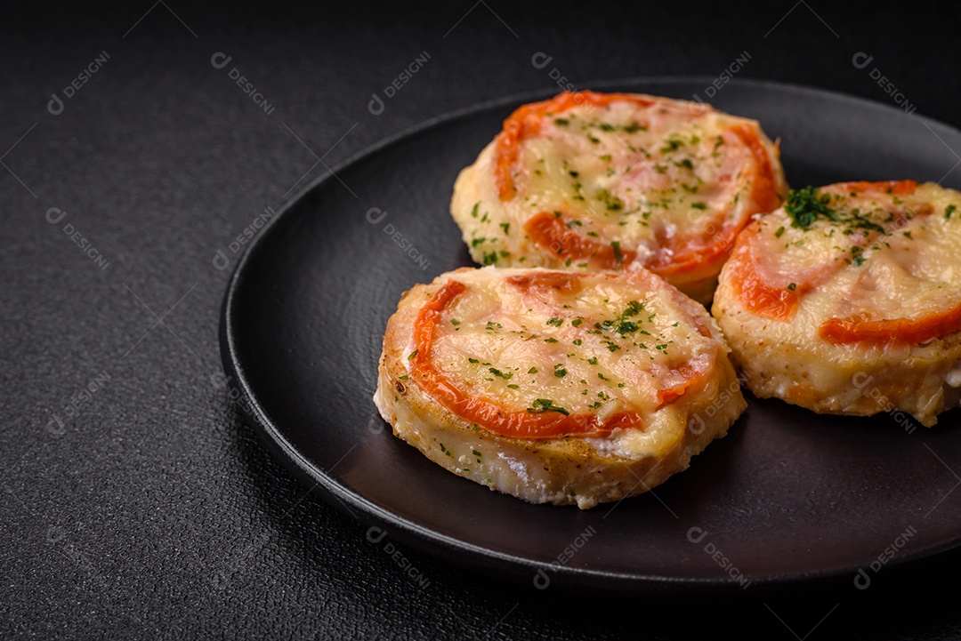 Delicioso filé de peixe assado com queijo, tomate, sal, especiarias e ervas sobre um fundo escuro de concreto