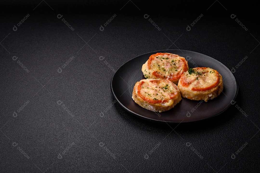 Delicioso filé de peixe assado com queijo, tomate, sal, especiarias e ervas sobre um fundo escuro de concreto