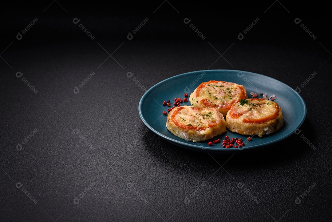 Delicioso filé de peixe assado com queijo, tomate, sal, especiarias e ervas sobre um fundo escuro de concreto