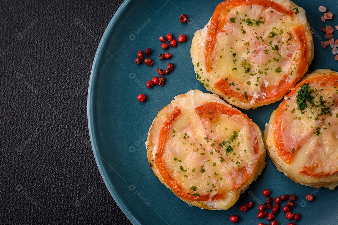 Delicioso filé de peixe assado com queijo, tomate, sal, especiarias e ervas sobre um fundo escuro de concreto