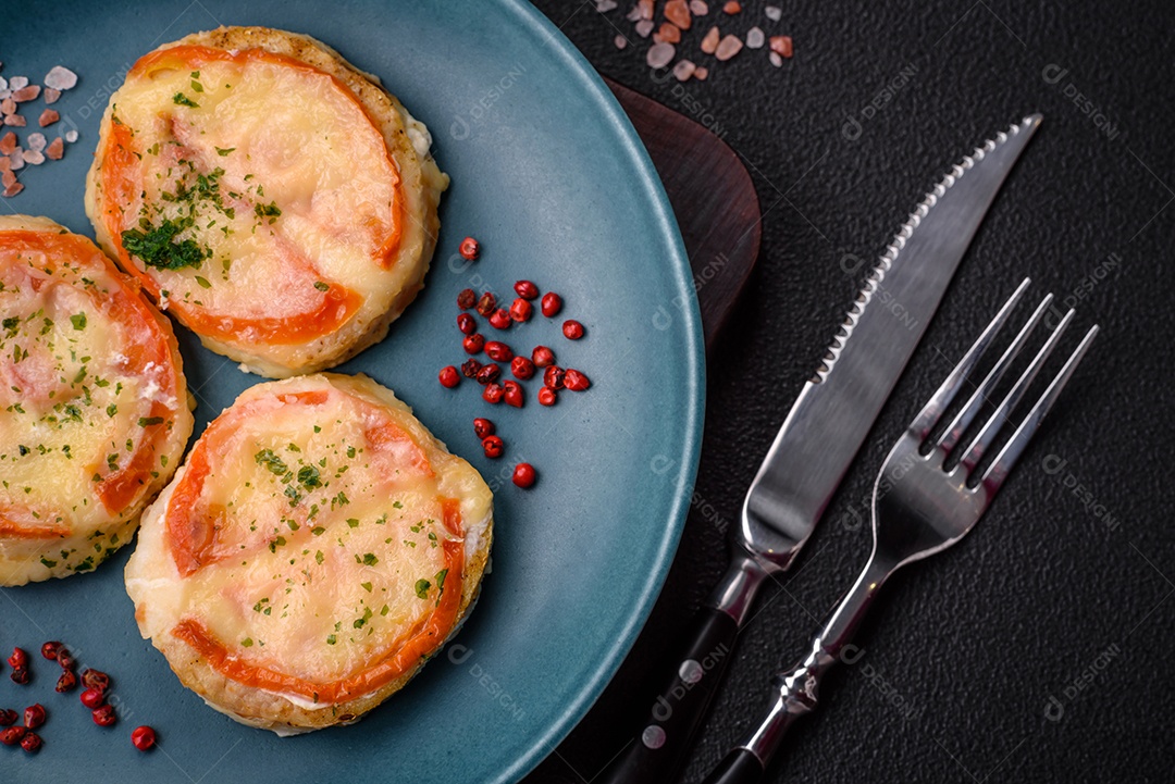 Delicioso filé de peixe assado com queijo, tomate, sal, especiarias e ervas sobre um fundo escuro de concreto