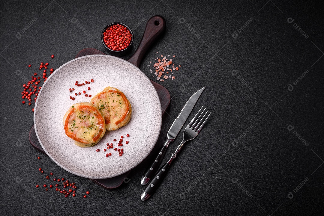 Delicioso filé de peixe assado com queijo, tomate, sal, especiarias e ervas sobre um fundo escuro de concreto