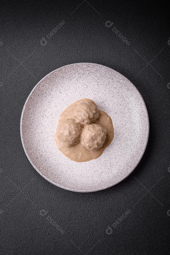 Deliciosas almôndegas de frango ou peru picado com molho de creme de leite com sal e especiarias num prato de cerâmica