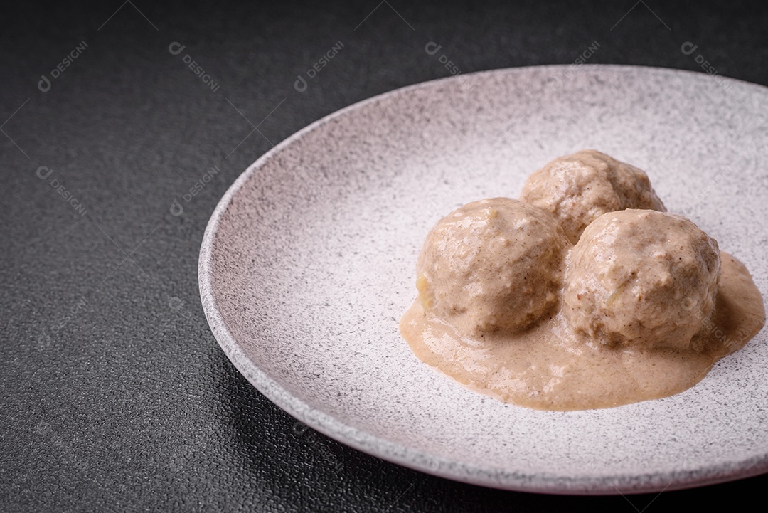 Deliciosas almôndegas de frango ou peru picado com molho de creme de leite com sal e especiarias num prato de cerâmica