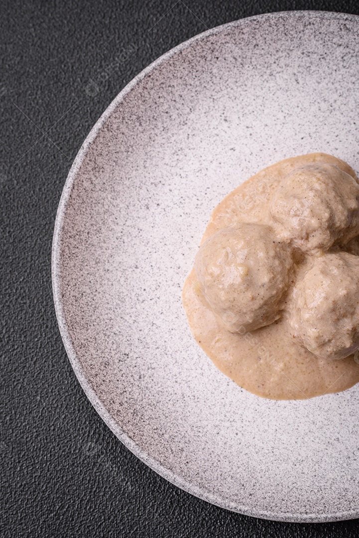 Deliciosas almôndegas de frango ou peru picado com molho de creme de leite com sal e especiarias num prato de cerâmica