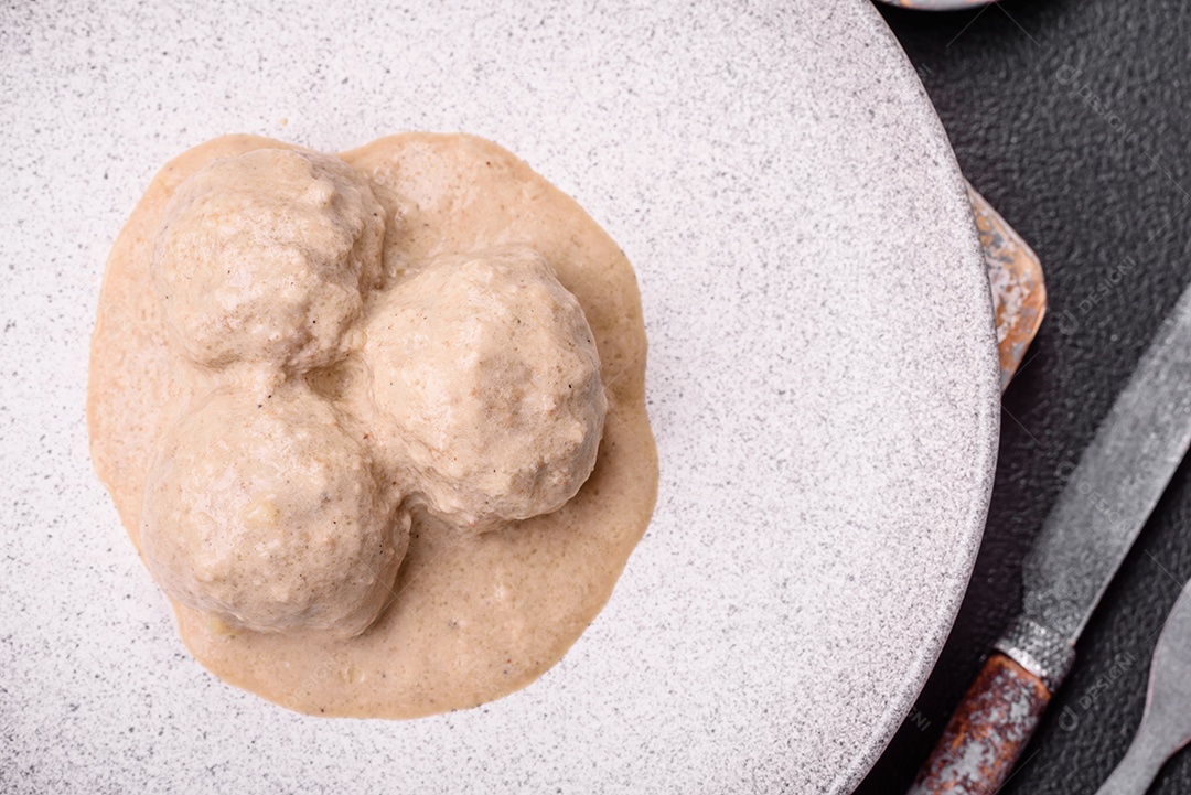 Deliciosas almôndegas de frango ou peru picado com molho de creme de leite com sal e especiarias num prato de cerâmica