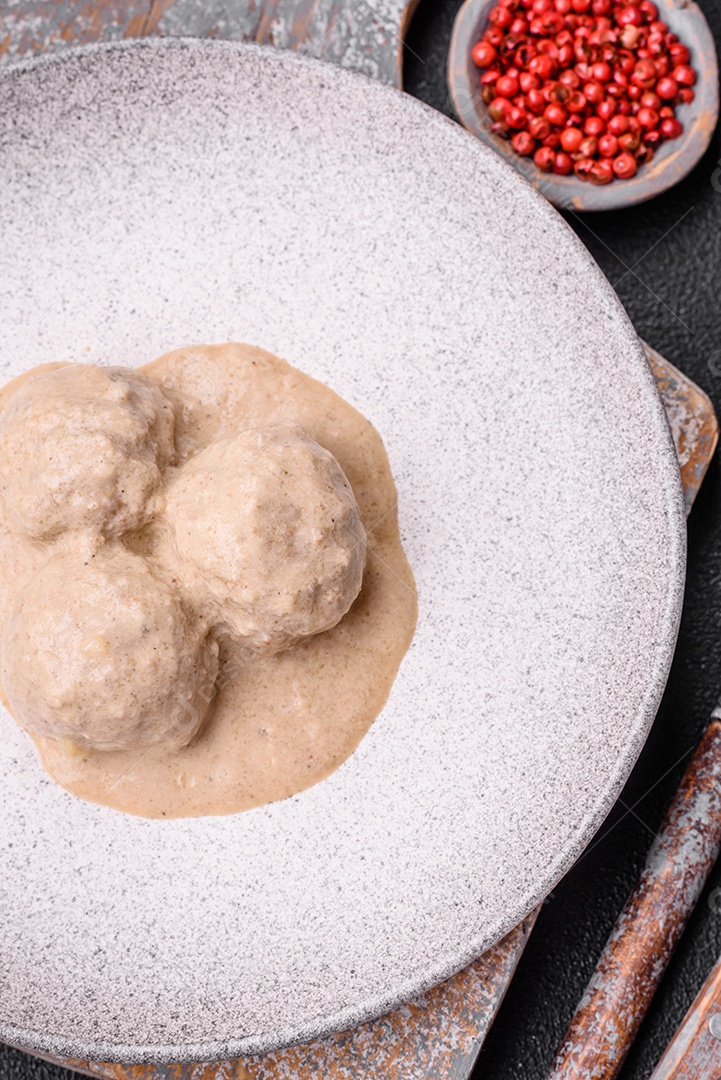 Deliciosas almôndegas de frango ou peru picado com molho de creme de leite com sal e especiarias num prato de cerâmica