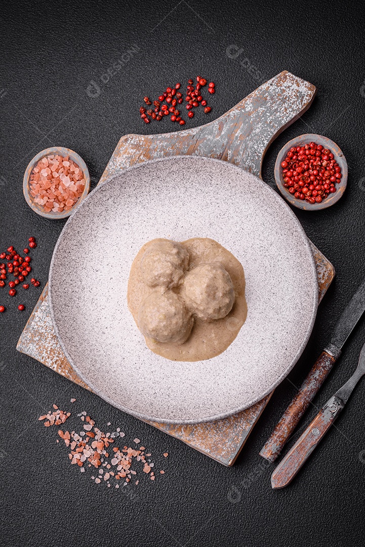 Deliciosas almôndegas de frango ou peru picado com molho de creme de leite com sal e especiarias num prato de cerâmica