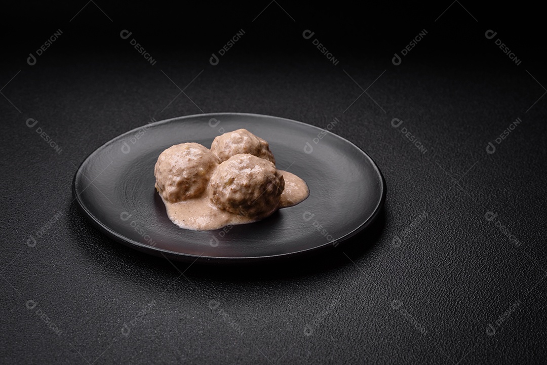 Deliciosas almôndegas de frango ou peru picado com molho de creme de leite com sal e especiarias num prato de cerâmica