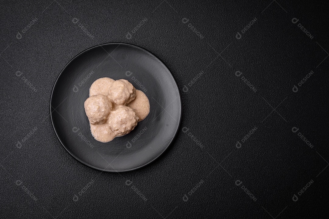 Deliciosas almôndegas de frango ou peru picado com molho de creme de leite com sal e especiarias num prato de cerâmica