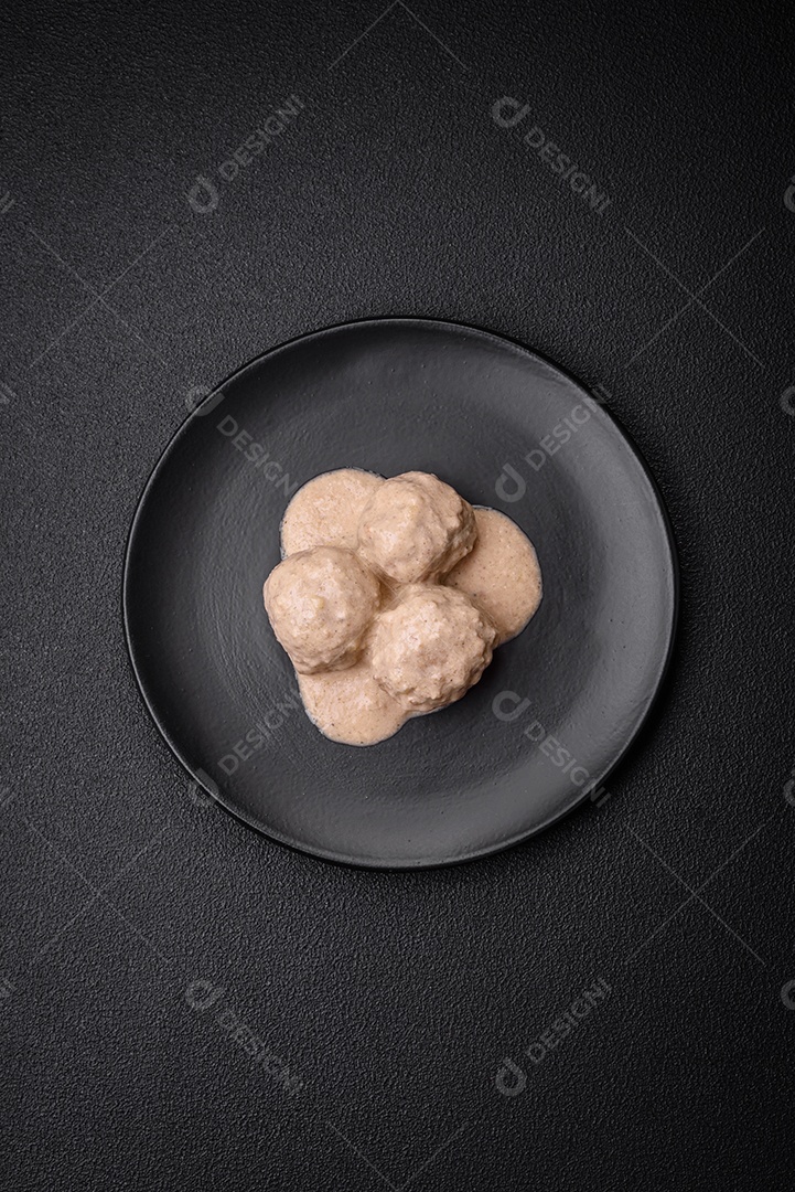 Deliciosas almôndegas de frango ou peru picado com molho de creme de leite com sal e especiarias num prato de cerâmica