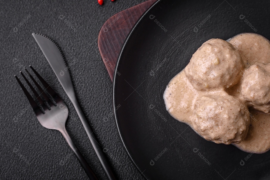 Deliciosas almôndegas de frango ou peru picado com molho de creme de leite com sal e especiarias num prato de cerâmica